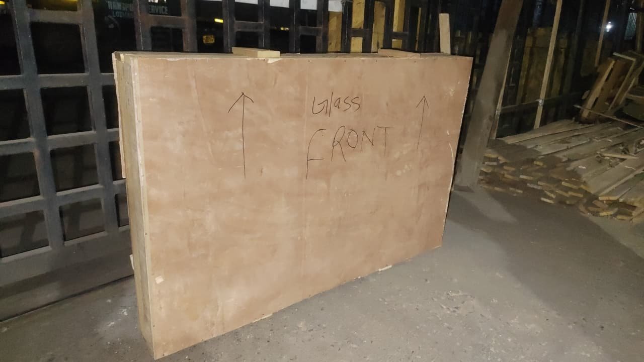 Custom wooden crate built for a glass-front item, marked for careful handling